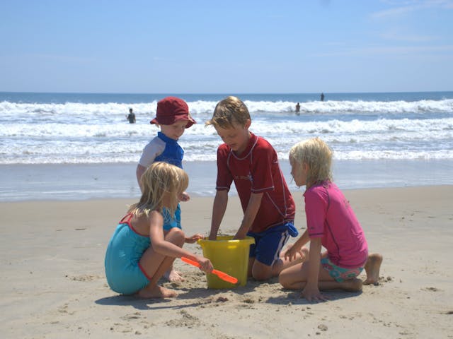 Spelende kinderen op strand bij Callassande